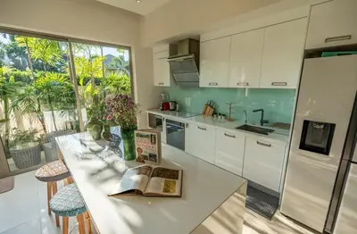 a kitchen with white cabinets and a table with a book on it at Villa Allamanda 3 Bdrm Best Location Bangtao Beach VVPHU88 in Phuket