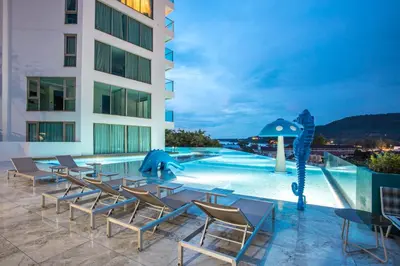 a hotel patio with chairs and a swimming pool at Prime Location Kamala Ocean View Suite OCN C64 just 450m to the Beach in Kamala Beach