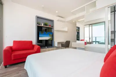 a bedroom with a bed and a red chair at Prime Location Kamala Ocean View Suite OCN C64 just 450m to the Beach in Kamala Beach