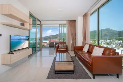 a living room with a couch and a television at Kamala Ocean View 2BR Apartment OCN C35, just 5 min walk to the Beach in Kamala Beach