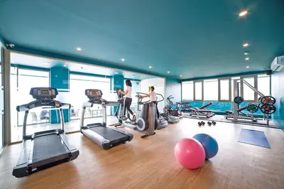 a gym with two women in a gym with exercise equipment at Kamala Ocean View 2BR Apartment OCN C35, just 5 min walk to the Beach in Kamala Beach