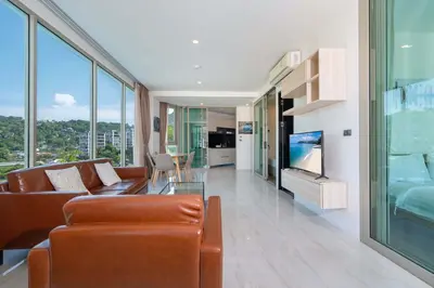 a living room with a couch and a tv at Kamala Ocean View 2BR Apartment OCN C35, just 5 min walk to the Beach in Kamala Beach