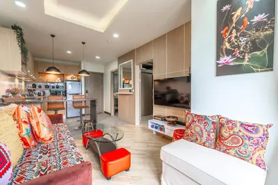 a living room with a couch and a kitchen at C214 Condo Seaview Pools Gym Walk to Rawai Beach in Rawai Beach