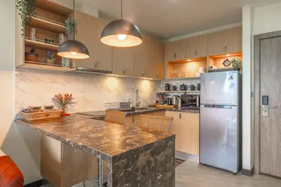 a kitchen with a large counter and a refrigerator at C214 Condo Seaview Pools Gym Walk to Rawai Beach in Rawai Beach