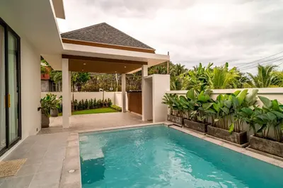 a swimming pool in the backyard of a house at Narinsaya Pool villas in Nai Yang Beach