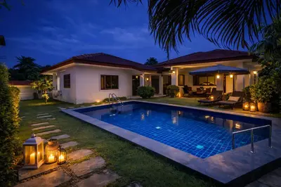 a swimming pool in the yard of a house at night at Villa Lilly in Rawai Beach