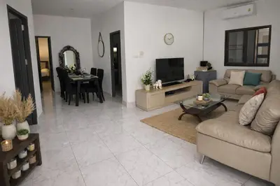 a living room with a couch and a tv and a table at Villa Lilly in Rawai Beach