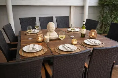 a wooden table with a statue of a head and wine glasses at Villa Lilly in Rawai Beach