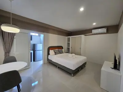 a bedroom with a bed and a tv in it at Hommory Residence - Phuket Town in Ban Lo Long
