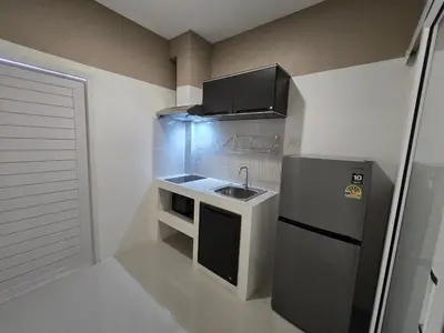 a small kitchen with a sink and a refrigerator at Hommory Residence - Phuket Town in Ban Lo Long