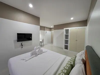 a bedroom with a bed with a bow on it at Hommory Residence - Phuket Town in Ban Lo Long