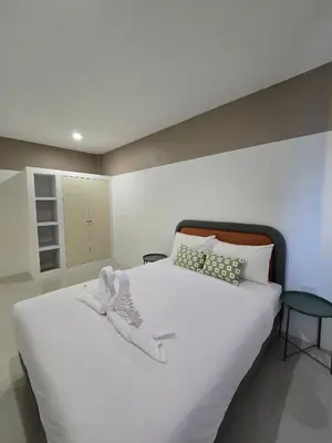 a bedroom with a large white bed with shoes on it at Hommory Residence - Phuket Town in Ban Lo Long