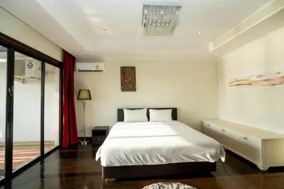 a bedroom with a white bed and a red curtain at Laguna Luxure Private Pool Villa in Layan Beach