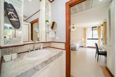 a bathroom with a sink and a bedroom at Allamanda Townhouse Laguna Phuket Bang Tao Beach in Laguna Phuket