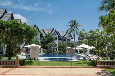 a resort with a swimming pool and palm trees at Allamanda Townhouse Laguna Phuket Bang Tao Beach in Laguna Phuket