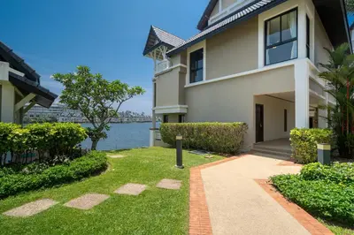 a house with a walkway in front of the water at Allamanda Townhouse Laguna Phuket Bang Tao Beach in Laguna Phuket