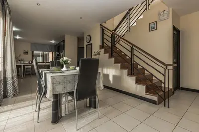 a dining room with a table and a staircase at Villa Belloro Bang Tao 3BR East Residence in Ban Pak Lak