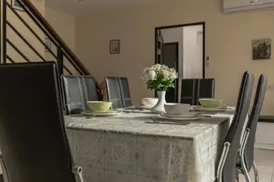 a table with chairs and a vase of flowers on it at Villa Belloro Bang Tao 3BR East Residence in Ban Pak Lak