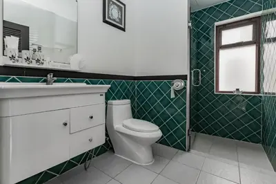 a bathroom with a toilet and a sink and a window at Villa Belloro Bang Tao 3BR East Residence in Ban Pak Lak