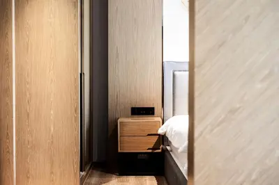 a small bedroom with a bed and a mirror at Suite Aura 1BR PoolsGyms Shuttle to Nai Harn in Rawai Beach