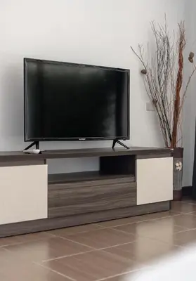 a flat screen tv sitting on top of a entertainment center at Villa Elara Bang Tao 3BR Pool East Residence in Ban Pak Lak