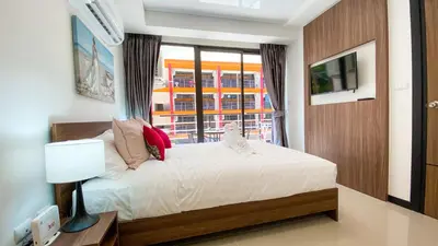a bedroom with a white bed and a window at ARIA Condo 1BR Pool View NBC Nai Harn in Phuket Town