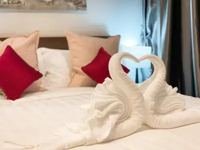two white swans making a heart on a bed at ARIA Condo 1BR Pool View NBC Nai Harn in Phuket Town
