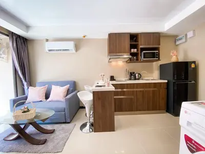 a small apartment with a blue couch and a kitchen at ARIA Condo 1BR Pool View NBC Nai Harn in Phuket Town