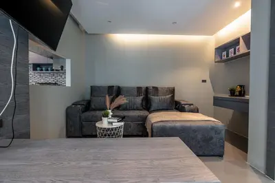 a living room with a couch and a chair at Suite Altair 2BRPool RooftopBarCitygate Kamala in Phuket Town
