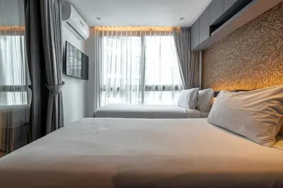 a hotel room with a large bed and a window at Suite Altair 2BRPool RooftopBarCitygate Kamala in Phuket Town