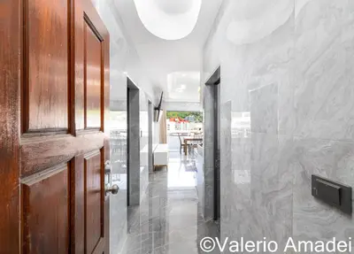 a hallway with a door and a dining room at OMNIAPHUKET - Patong Tower - Premium 3 Bedrooms Apartment in Patong Beach