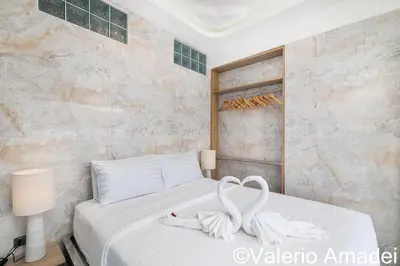 a bedroom with a white bed with two white towels at OMNIAPHUKET - Patong Tower - Premium 3 Bedrooms Apartment in Patong Beach