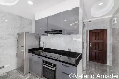 a kitchen with a sink and a refrigerator at OMNIAPHUKET - Patong Tower - Premium 3 Bedrooms Apartment in Patong Beach