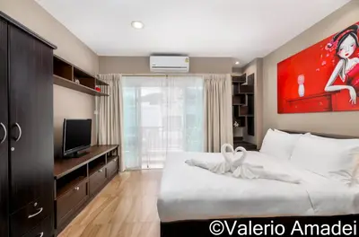 a bedroom with a large bed and a television at OMNIAPHUKET - Patong Center Pool Gym Near Bangla Road in Patong Beach