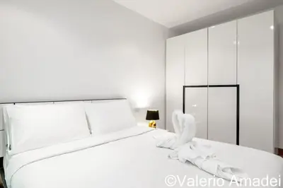 a bedroom with a white bed with white sheets at OMNIAPHUKET - Pool access 3 bedrooms apartment in Patong Beach