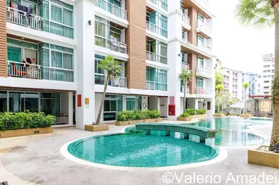 a swimming pool in front of a building at OMNIAPHUKET - Pool access 3 bedrooms apartment in Patong Beach