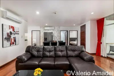 a living room with a brown leather couch at OMNIAPHUKET - Pool access 3 bedrooms apartment in Patong Beach