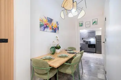 a dining room with a wooden table and green chairs at Wink 3 Patong Beach Phuket sleep 8 in Patong Beach
