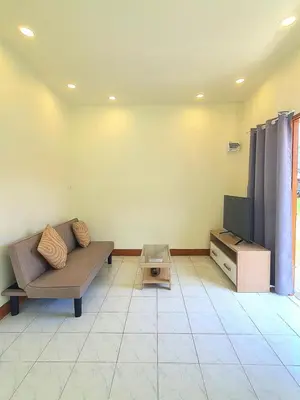 a living room with a couch and a tv at Home Hug local stay Bangtao in Bang Tao Beach