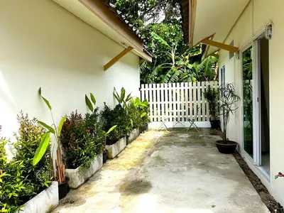 a courtyard of a house with plants and a fence at Home Hug local stay Bangtao in Bang Tao Beach
