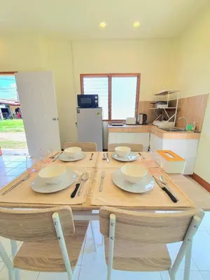 a wooden table with plates and glasses on it in a kitchen at Home Hug local stay Bangtao in Bang Tao Beach