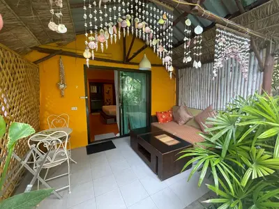 a patio with a couch and a table and some plants at Leon Oasis Nai Harn in Rawai Beach