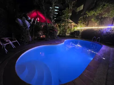 a blue swimming pool in a yard at night at Leon Oasis Nai Harn in Rawai Beach