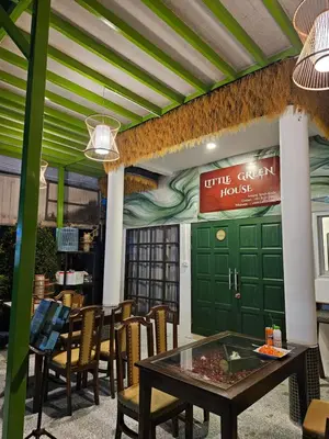 a restaurant with a table and chairs and a green door at Little Green House in Ao Nang Beach