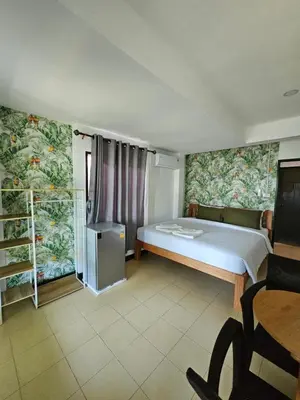 a bedroom with a bed and a desk and a chair at Little Green House in Ao Nang Beach