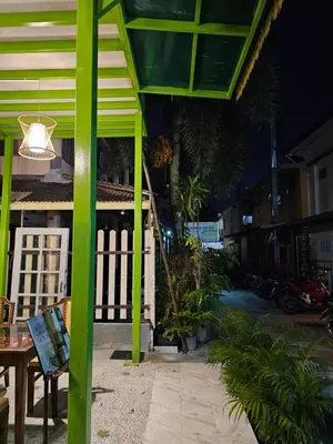 a building with green columns and a table and a light at Little Green House in Ao Nang Beach