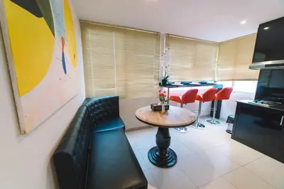 a living room with a couch and a table and chairs at Patong Condotel Penthouse 2 bedroom in Patong Beach