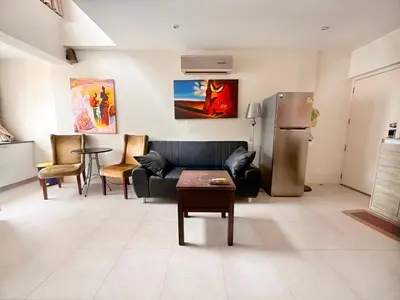 a living room with a couch and a refrigerator at Patong Penthouse 1 bedroom in Patong Beach
