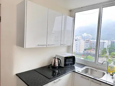 a kitchen with a microwave and a sink and a window at Patong Penthouse 1 bedroom in Patong Beach