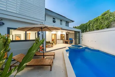 a house with a swimming pool and an umbrella at V215 ChaoFah Oasis Private Pool & Garden Retreat in Phuket Town